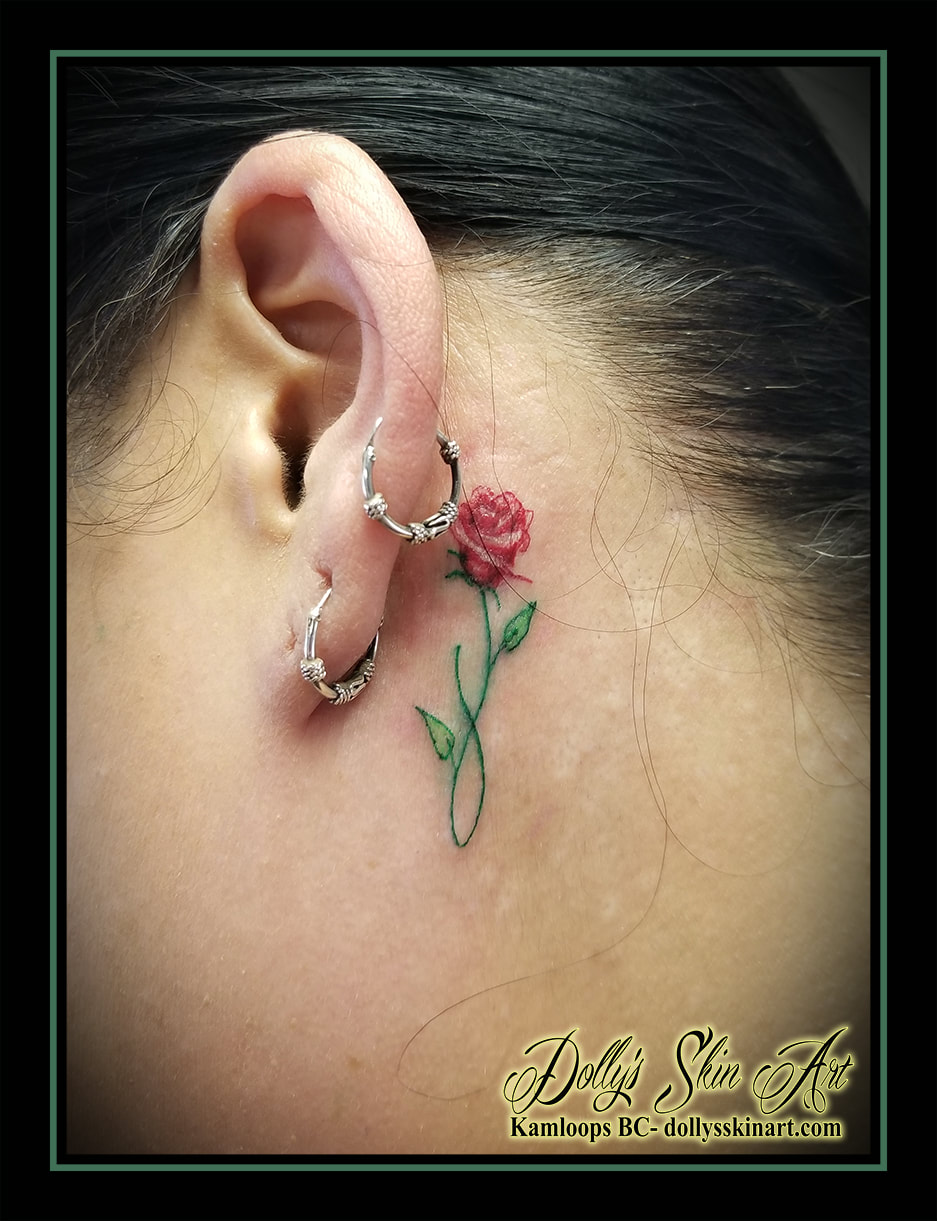 Red rose tattoo behind the right ear